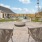 a patio with chairs and tables and fire pit in the middle