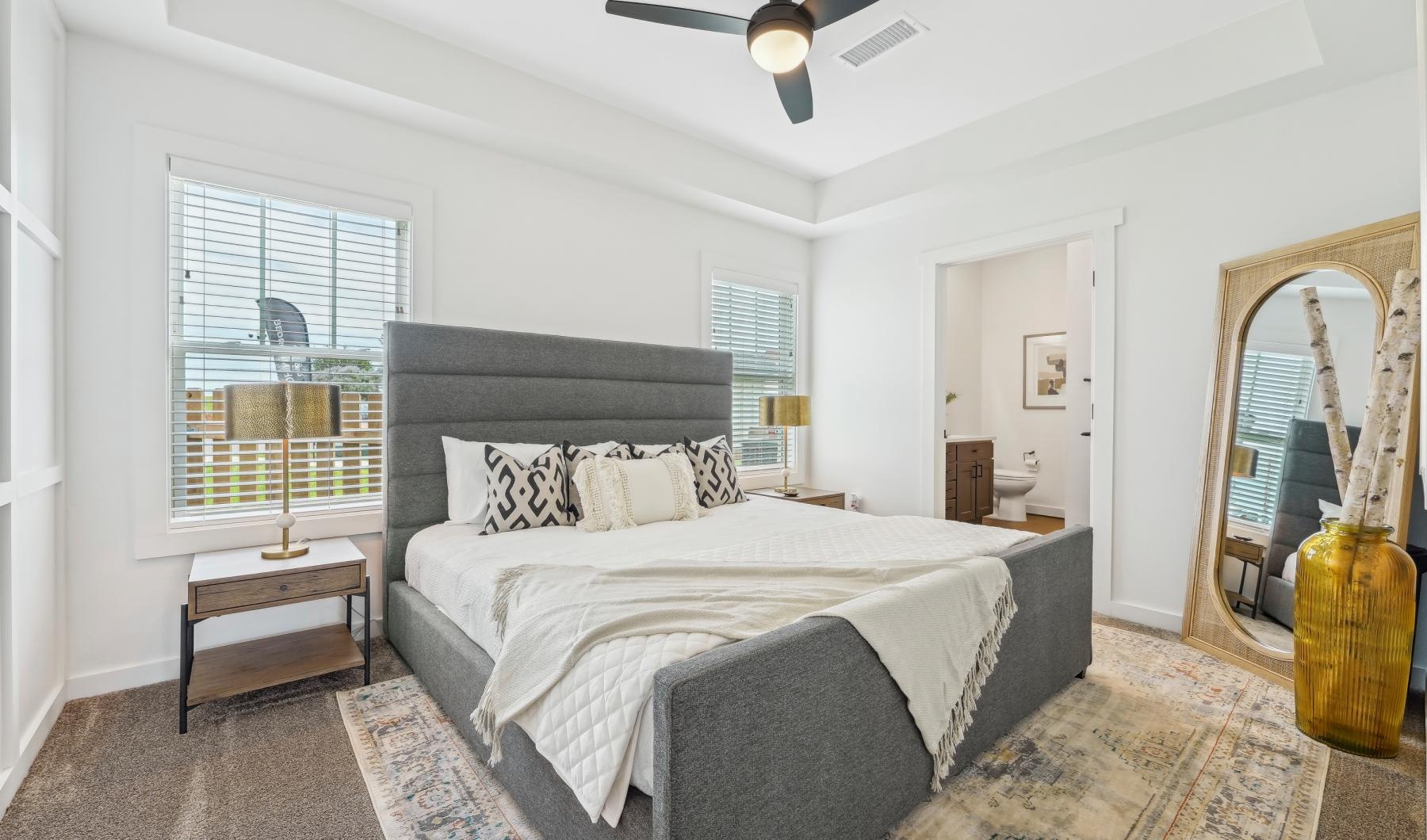 Relax and recharge in beautiful and spacious bedrooms a bedroom with a bed and a fan