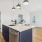 a kitchen with blue cabinets overlooking into the living rooom