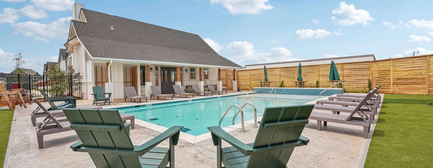 a swimming pool and chairs outside a building