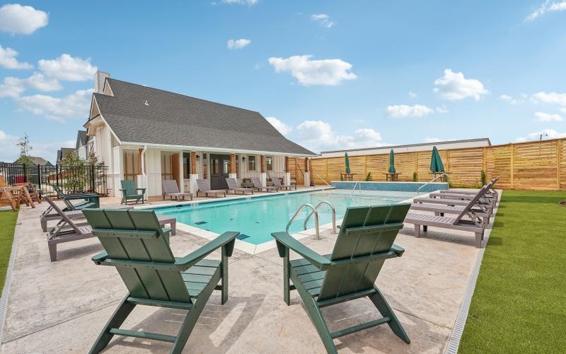 a swimming pool and chairs outside a building