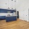a kitchen with blue cabinets and living room with wood floor