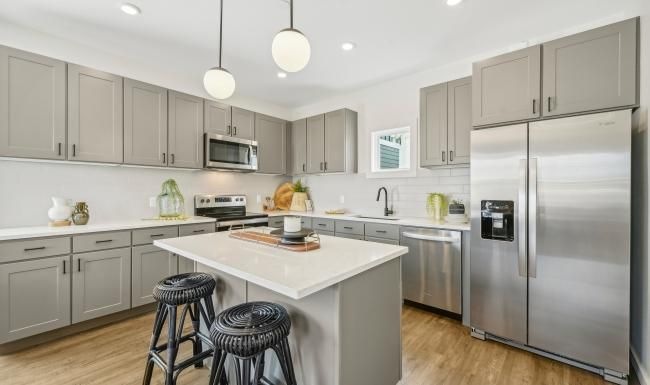 a kitchen with a fridge and stools
