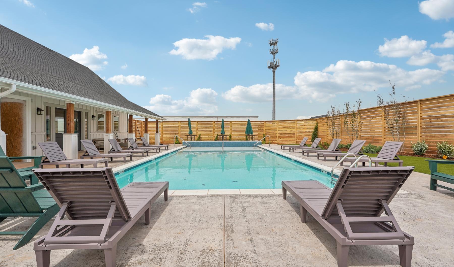 Resort-style swimming pool a pool with chairs around it